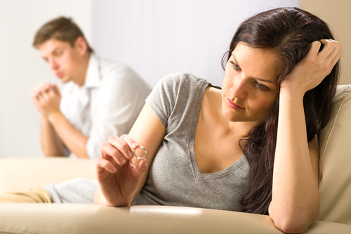 Couple contemplating relationship, holding ring.
