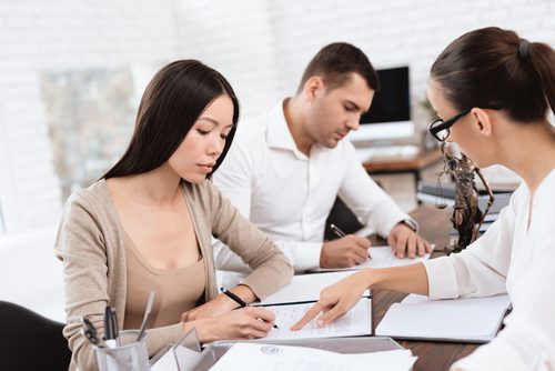 Three people discussing in an office setting.