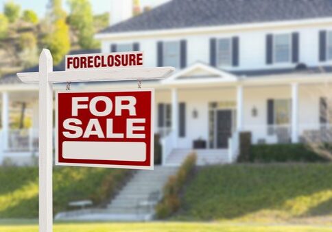 Foreclosure house with for sale sign.