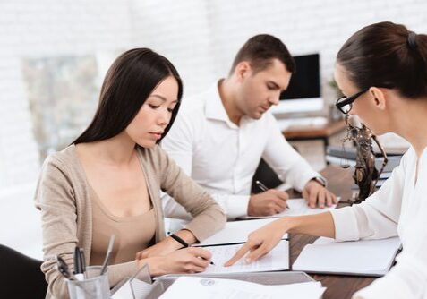 Three people discussing in an office setting.